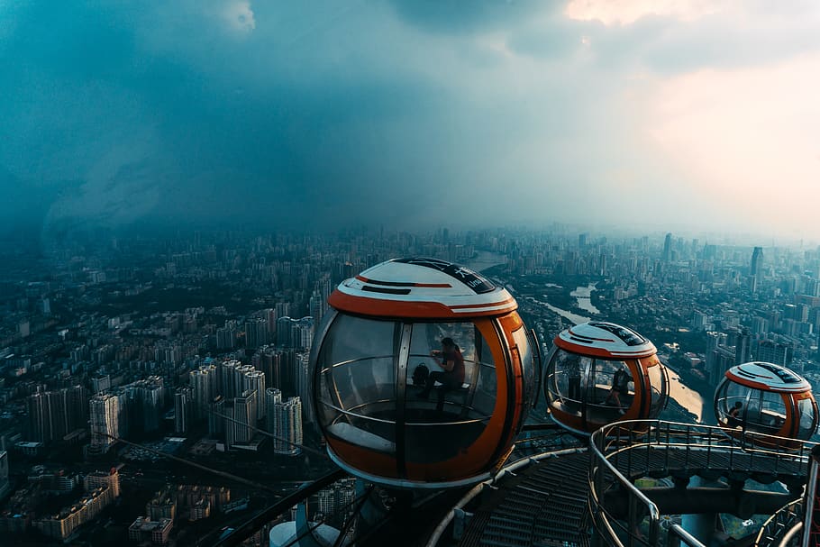 Aerial View of Red-and-white Enclosed Rides Overlooking City HD wallpaper