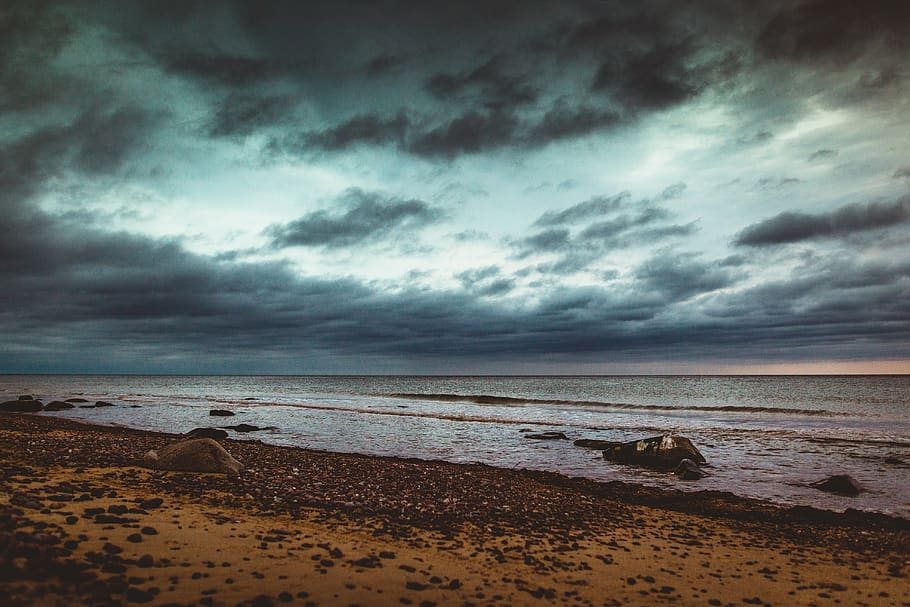 seashore, pebbles, rocks on beach, clouds, dark sky, cloudy sky HD wallpaper