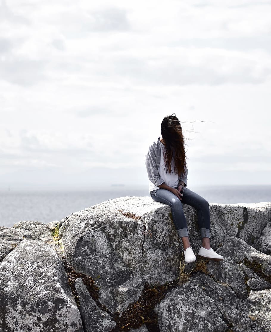 Woman Sits on Gray Rock, beach, clouds, daytime, landscape, ocean HD wallpaper