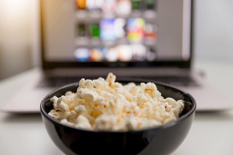 Watching movies online on laptop and eat popcorn., food and drink