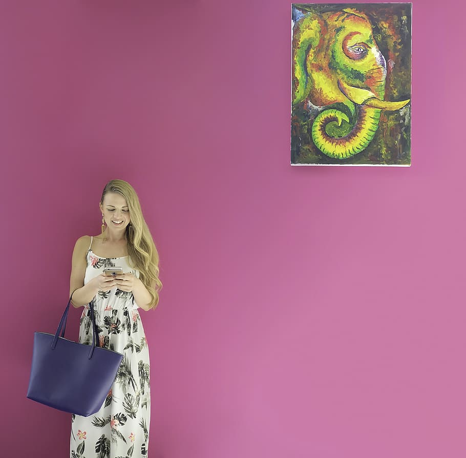 Woman Holding Smartphone and Blue Tote Bag While Leaning on Pink Wall With Elephant Painting, HD wallpaper