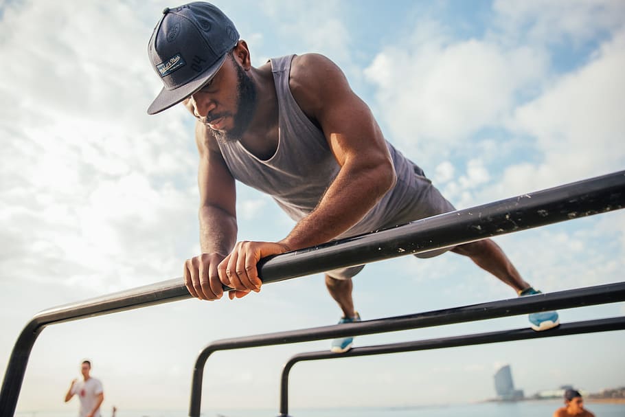 A young African man doing push-ups on bars on the beach, 25-30 year old, HD wallpaper