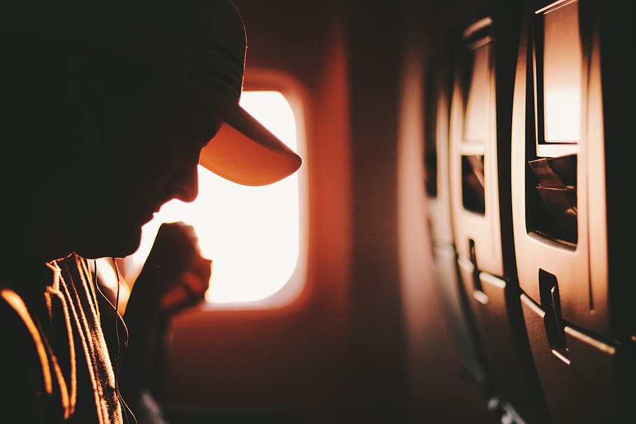 Man on Airplane Seat Wearing White Cap, blur, blurred background