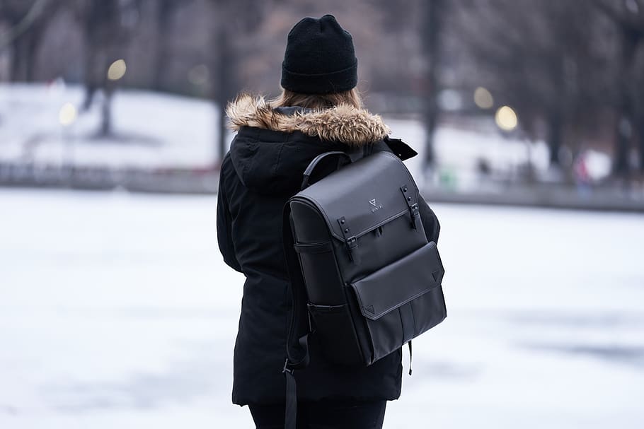 Woman Wearing Parka and Carrying Backpack during Winter, back view HD wallpaper