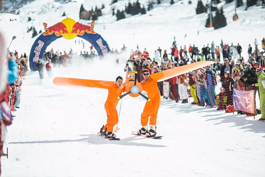 Photography of Men in Orange Suits Ridding Snowboard, action