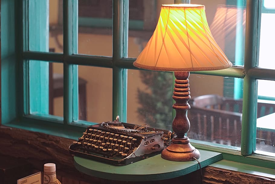 gray typewriter beside table lamp near window, india, srinagar
