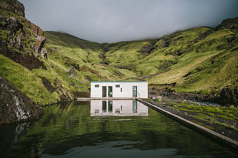 An outdoor mineral swimming pool in green mountains covered with clouds HD wallpaper