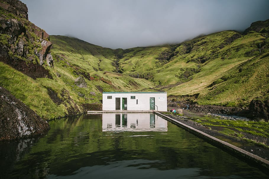 An outdoor mineral swimming pool in green mountains covered with clouds HD wallpaper
