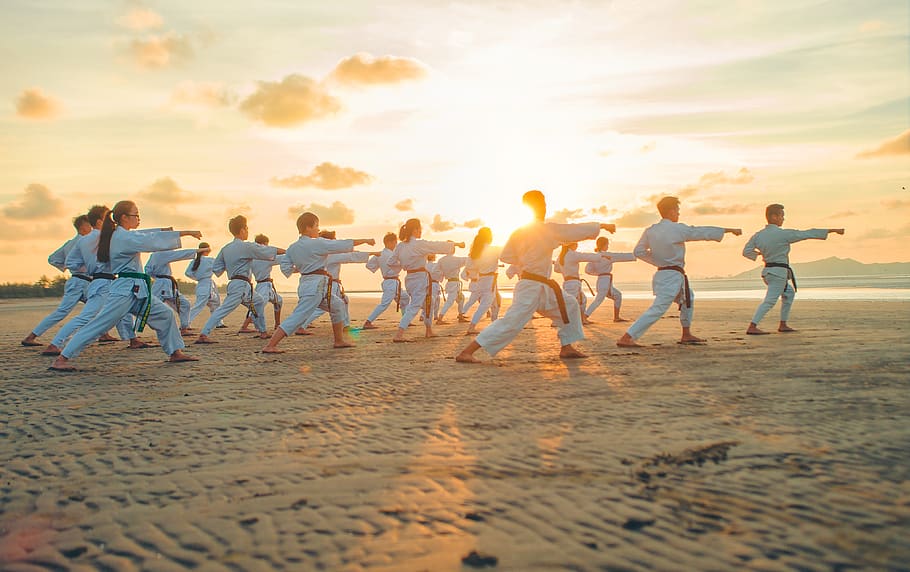 people wearing karate ji, sunset, sky, group of people, sea, beach