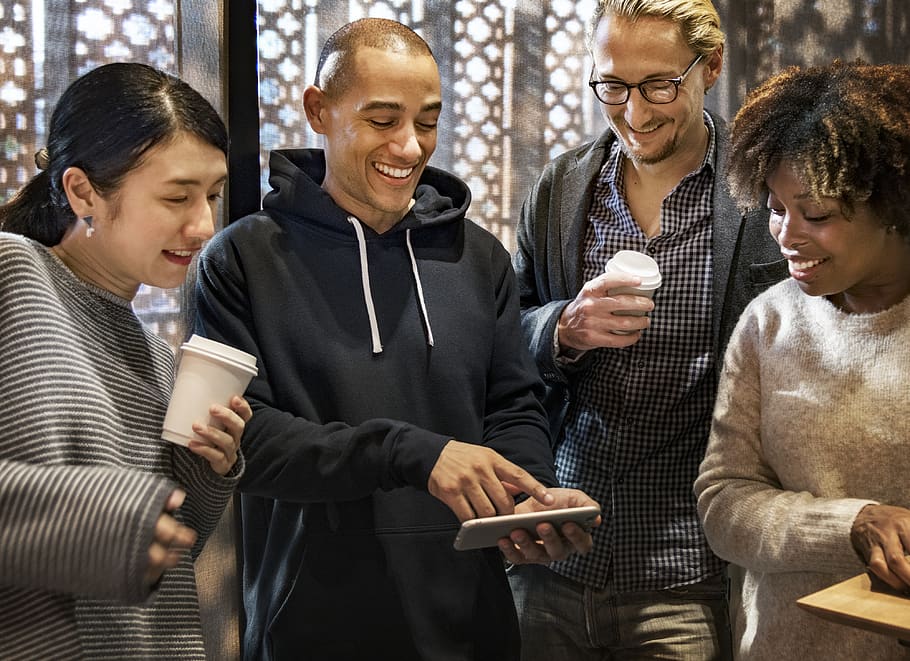 Group of Men and Women Smiling While Looking at Phone, casual
