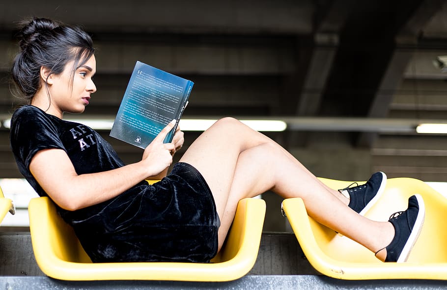 Woman in Black Velvet Dress and Black Sneakers Reading Book, beautiful