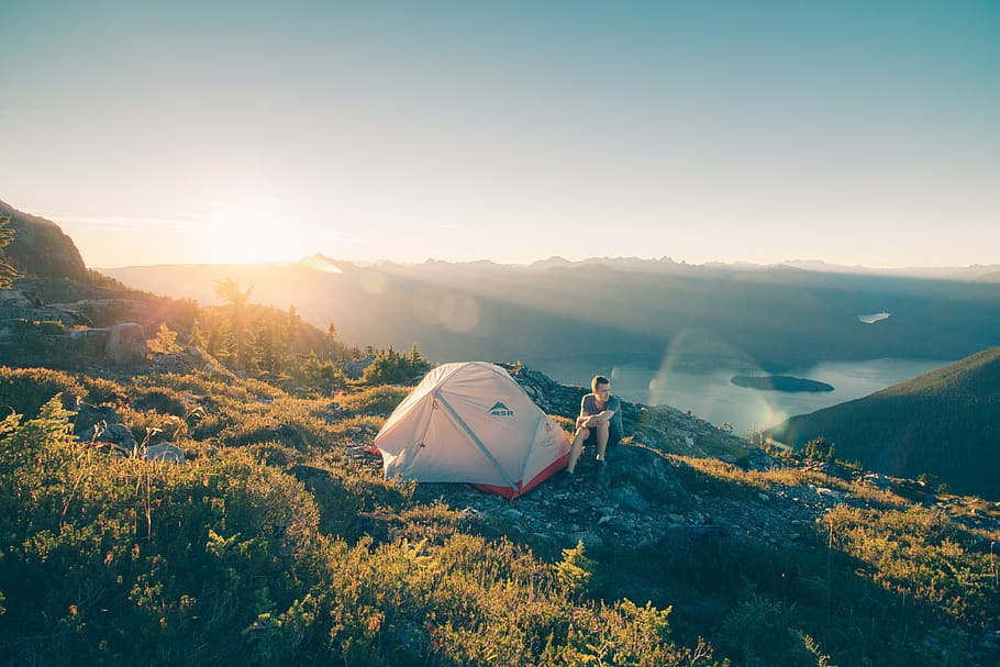 HD wallpaper: man sitting on stone beside white camping tent, mountain ...