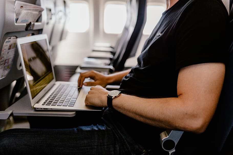Unrecognizable man with notebook sitting inside an airplane, adult HD wallpaper