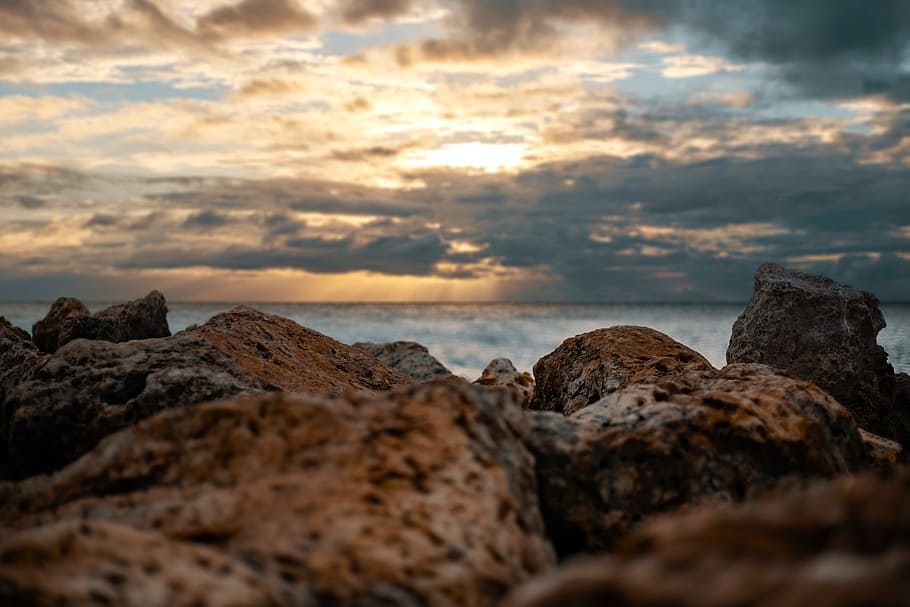 Brown Rocks Overlooking Body of Water, beach, close-up, clouds HD wallpaper