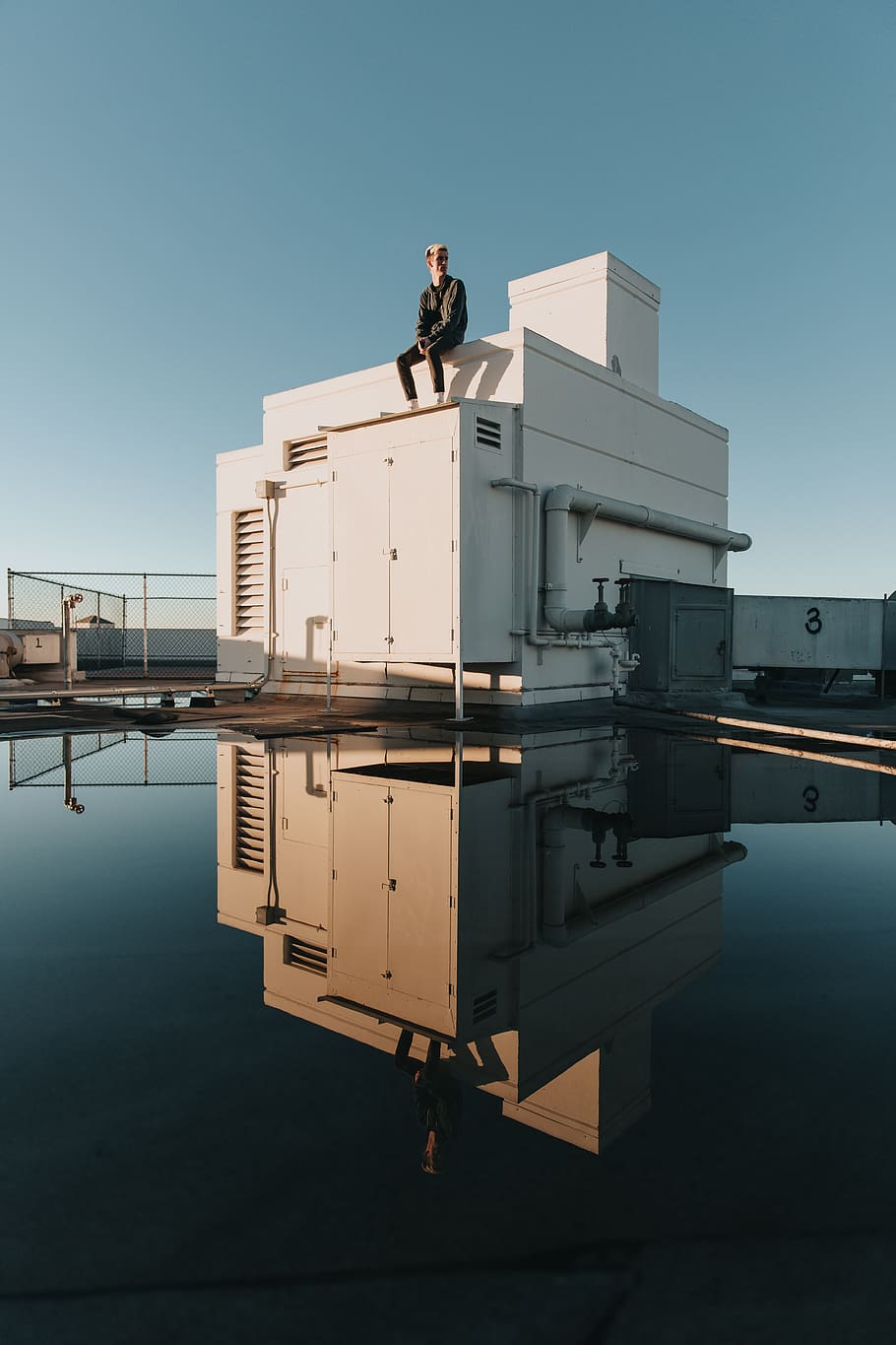 man sitting on shed, water, men, architecture, sky, clear sky HD wallpaper