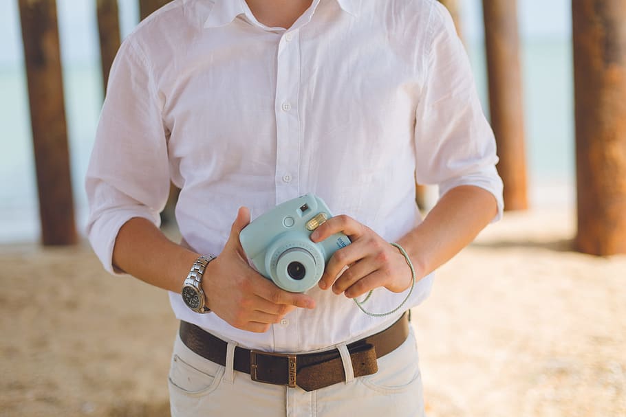 Man Holds Blue Fujufilm Instax Mini Camera, hands, holding, outdoors HD wallpaper