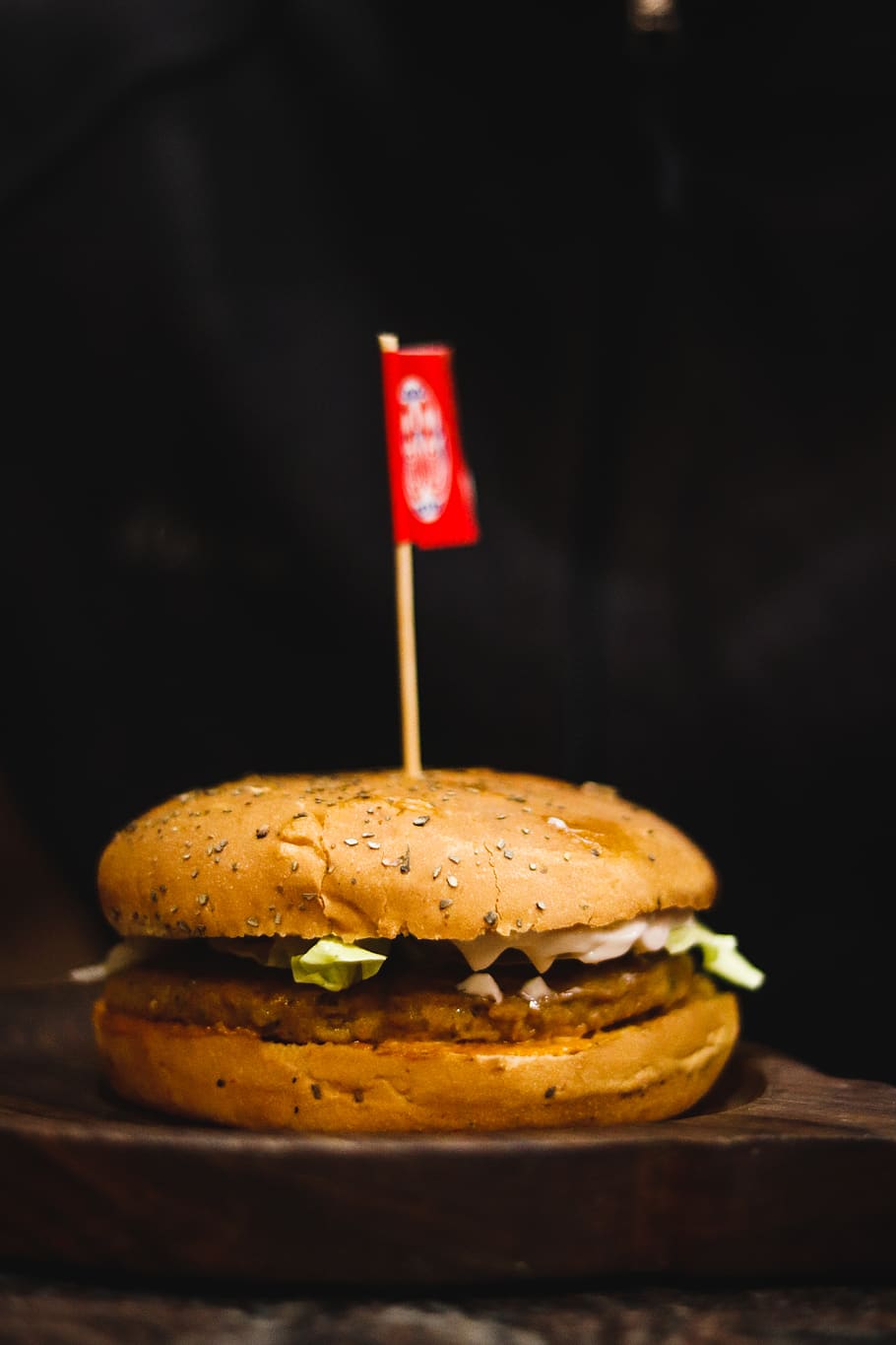 hamburger on wooden surface with small flag, food, bread, photography