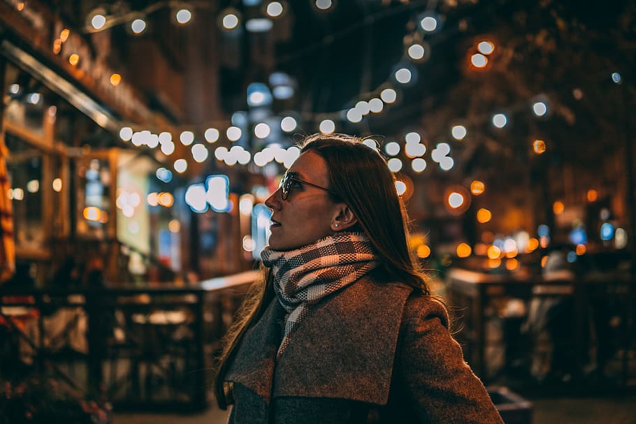 woman standing while looking right side under the string lights HD wallpaper