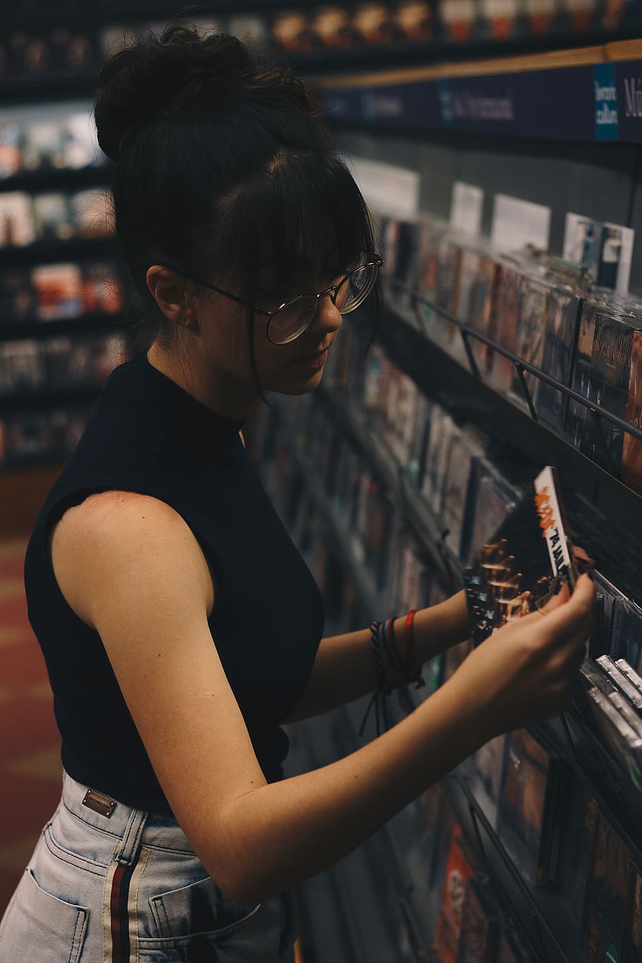 Woman Holding Cd Case Beside Cd Cases on Display Rack, bangs HD wallpaper