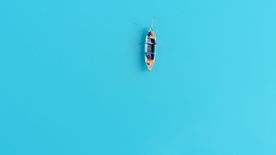 aerial photography of brown and blue canoe on body of water, minimal