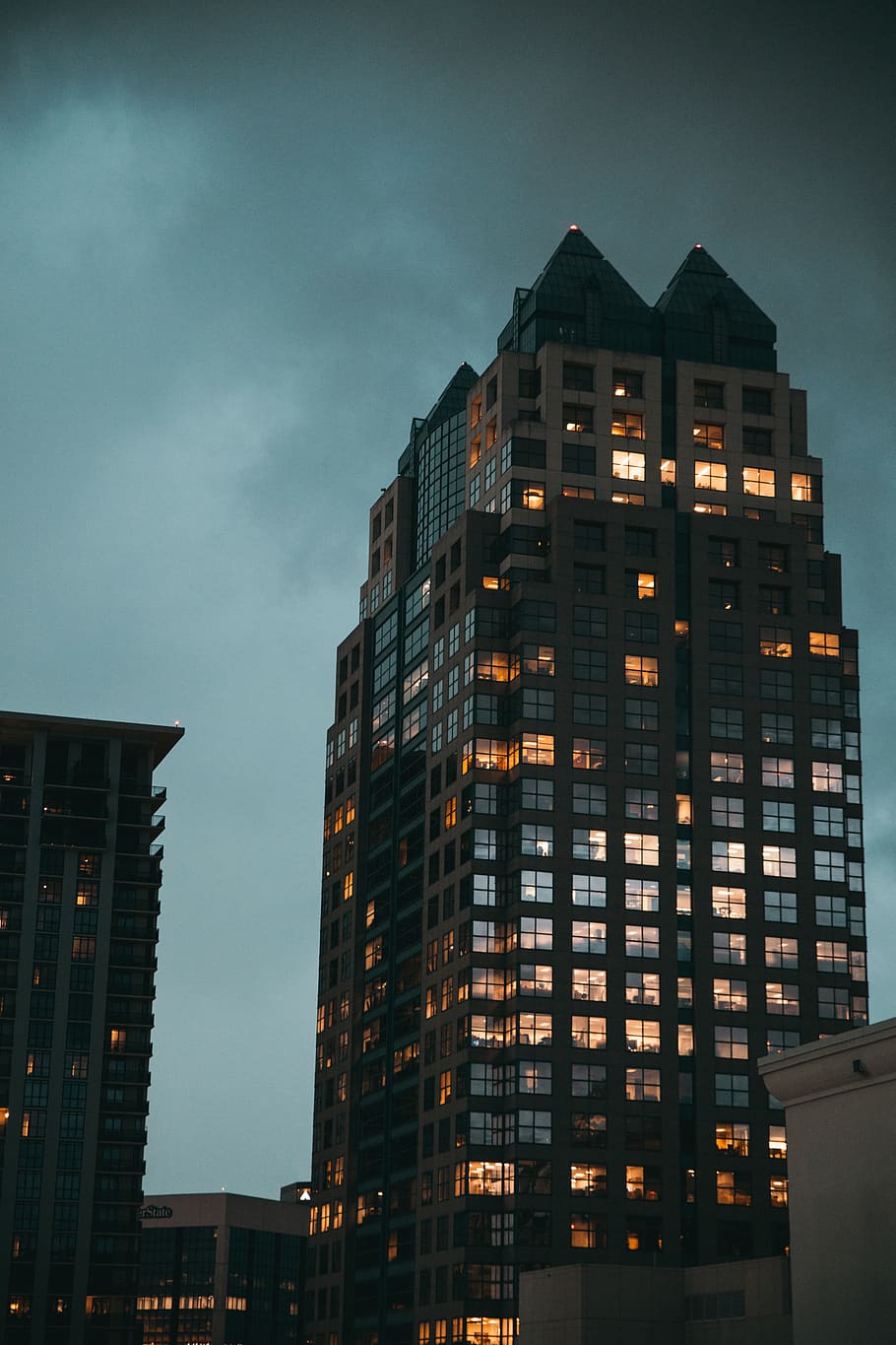 black glass-panel building under dark clouds, housing, high rise HD wallpaper