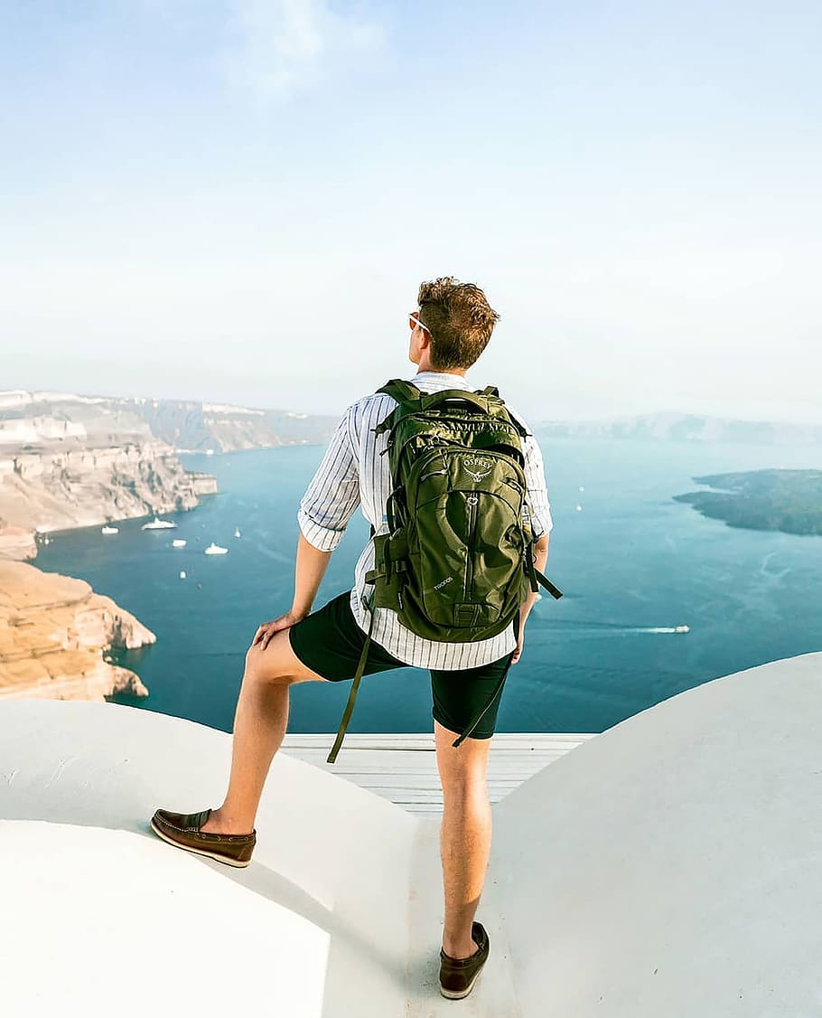 man on top of the white building during daytime, male, backpack HD wallpaper