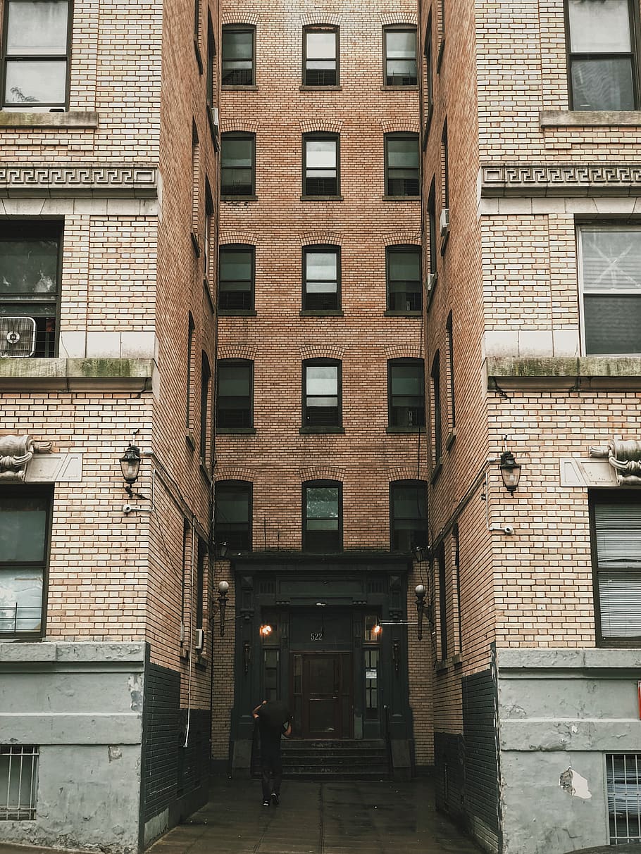 Person Standing Between Brown Concrete Building, apartment, architectural design HD wallpaper