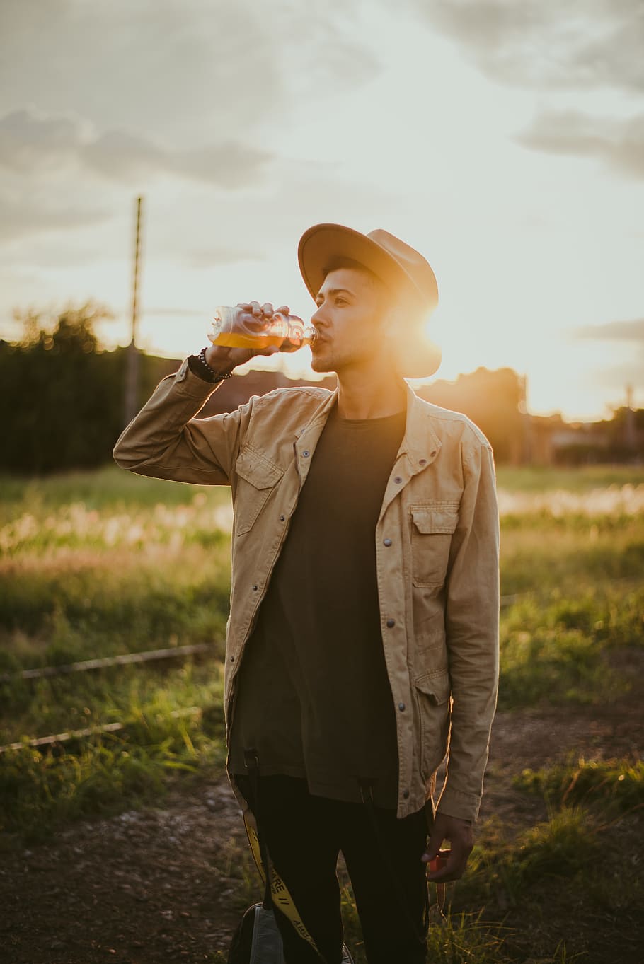 Photo of Man Drinking Juice Outside During Golden Hour, dawn