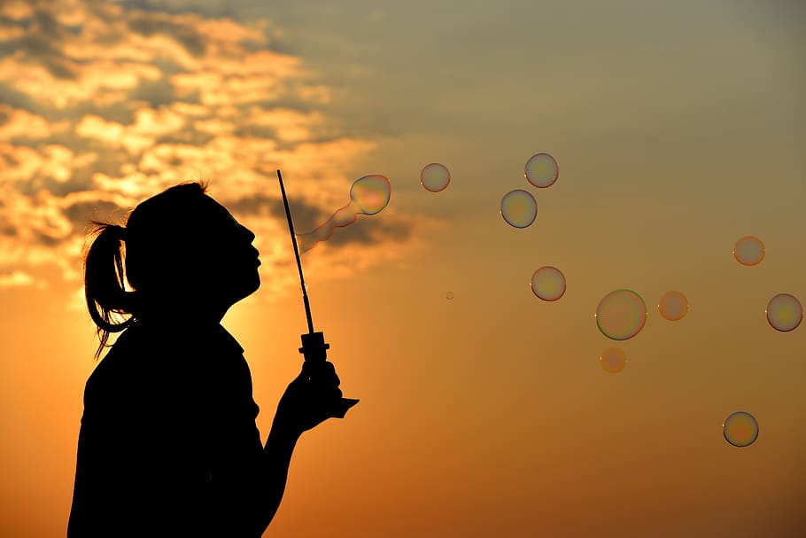 Silhouette Photo of Person Blowing Bubbles during Golden Hour HD wallpaper