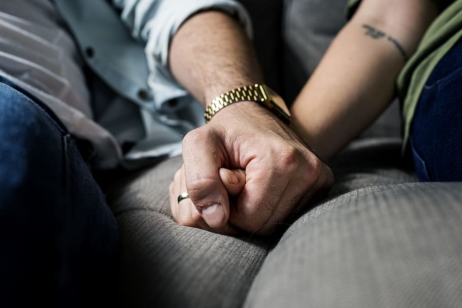 Two Person Holding Hands While Sitting on Grey Cushion, adult
