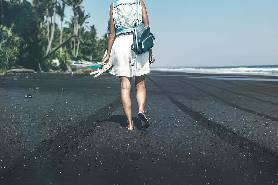 woman with backpack walking in the beach during daytime, black HD wallpaper