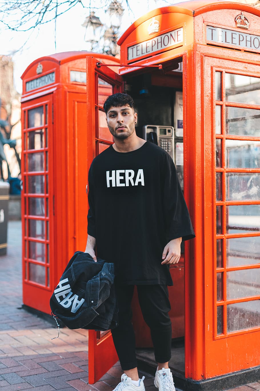 Man Standing Near Open Telephone Booth, casual, close-up, colors