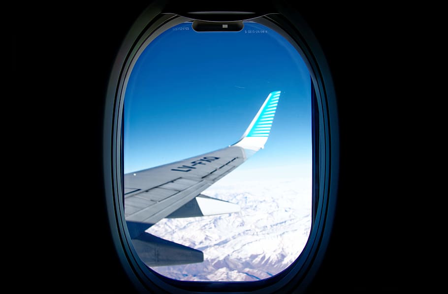 white airplane wing viewed over window, porthole, vehicle, transportation