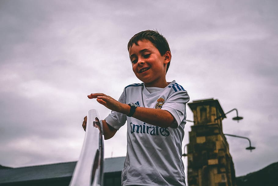 Boy in White and Blue Fly Emirates Jersey Shirt Holding on Stairs Grab Bar Under Gray Skies, HD wallpaper