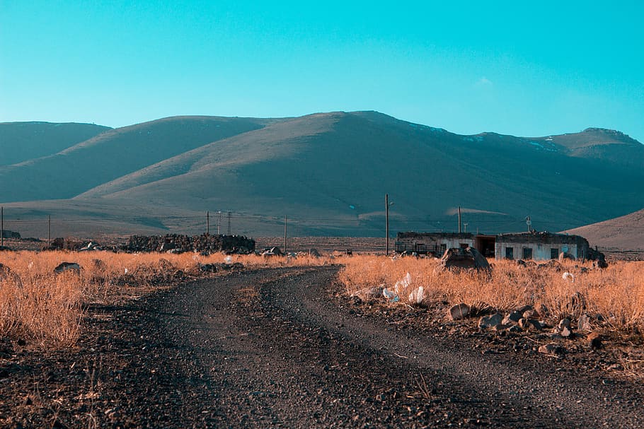 Gray Road in Between Brown Grass Field With Mountains Background HD wallpaper