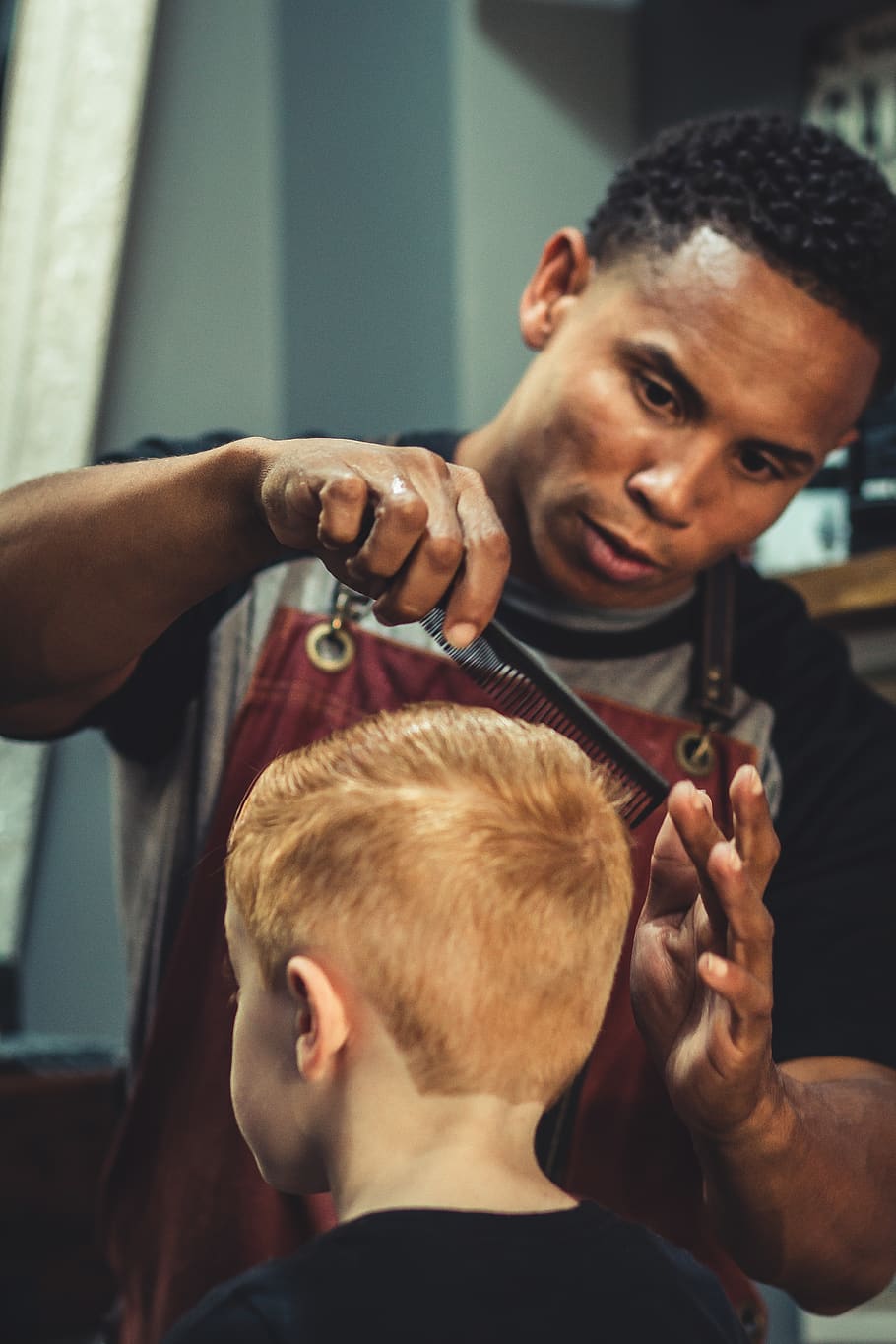 Boy Sitting Trimmed by Man Holding Scissor, barber, barbershop