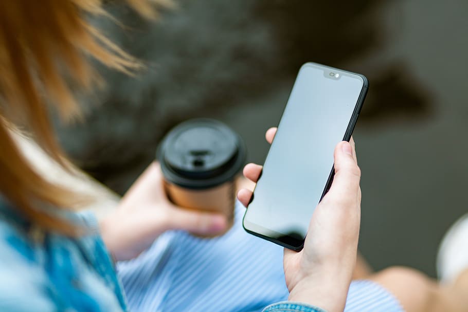 Woman Holding Black Smartphone With Black Screen, blurred background HD wallpaper