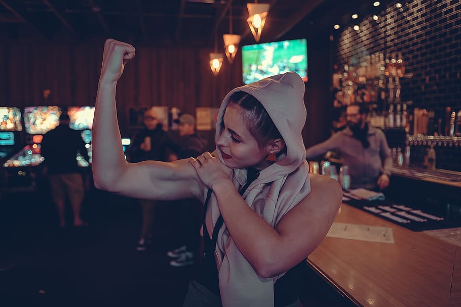 Woman Showing Biceps in Bar, bar tender, crowd, dark, hands, hoody sweater HD wallpaper