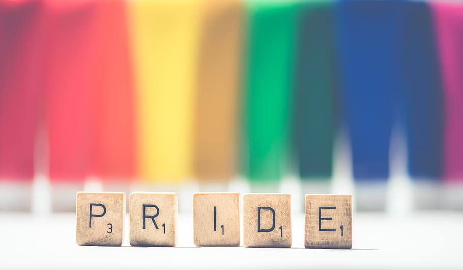 Selective Focus Photography of Scrabble Pride on White and Multicolored Background HD wallpaper