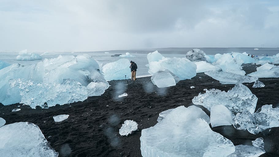 Person Standing Beside Body of Water, beach, black sand, climate change HD wallpaper