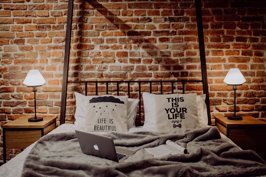 Enjoying evening with a Macbook in a nice bed, home, loft, brick wall