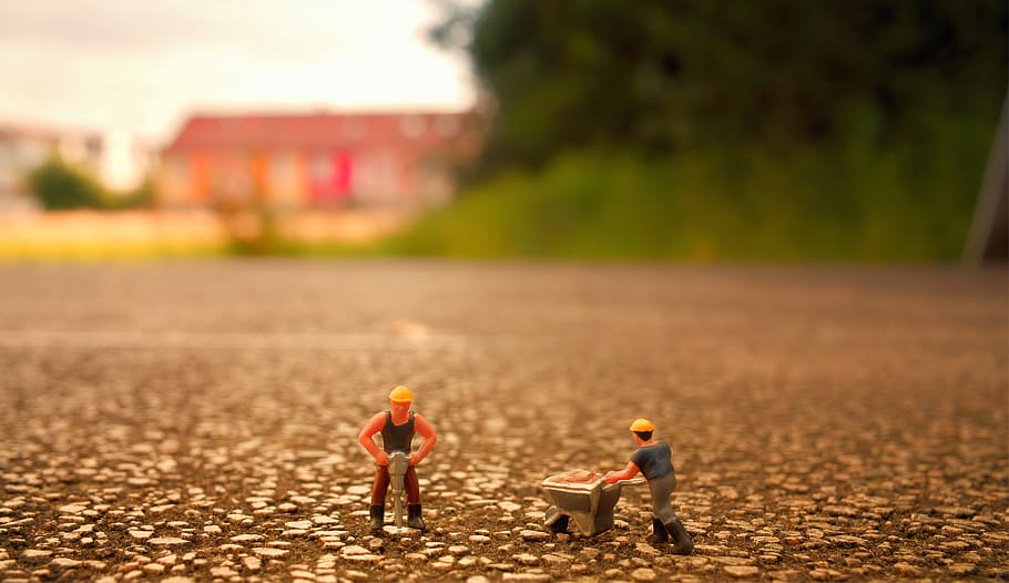 Selective Focus Photography of Two Men Builder Figurines, blurred background
