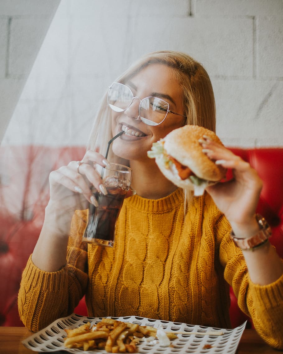 woman sitting while holding burger, female, food, eat, fries
