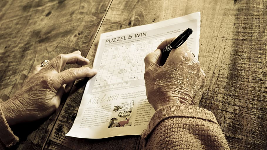 Person Writing on Puzzle & Win Paper, hands, matthias zomer, pen