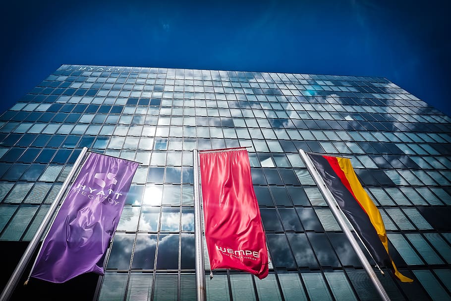 Red Flag Near Buildings, architecture, flags, glass, hotel, low angle shot HD wallpaper