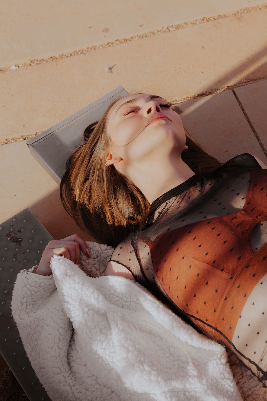 woman lying on brown concrete pavement, portrait, rest, fashion