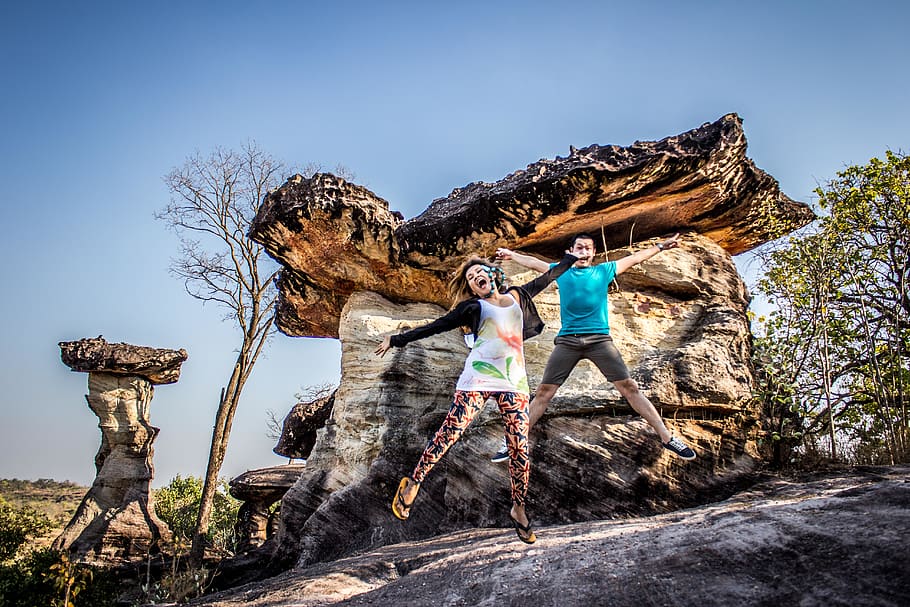 Man and Woman Jumping on Rocky Cliff, action, active, adults HD wallpaper