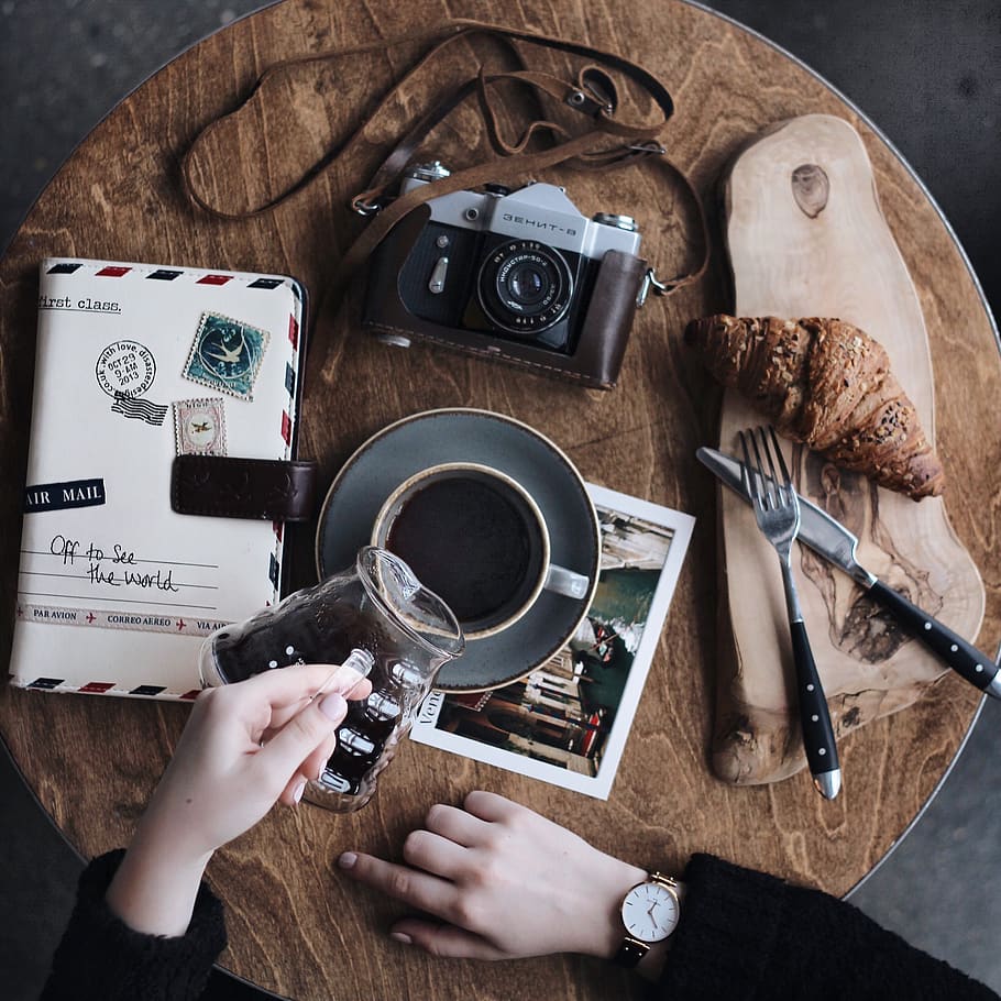 Baked Bread on Brown Wooden Surface Beside Grey Point-and-shoot Camera on Table HD wallpaper