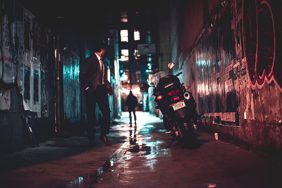 man walking beside black motorcycle, person, human, vehicle, transportation