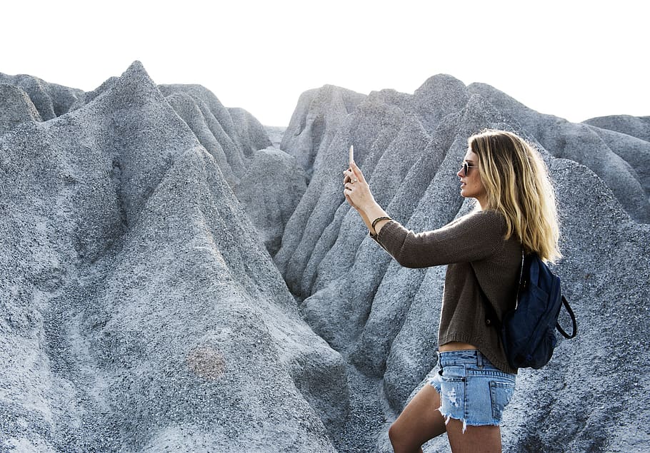 Woman Taking Photo of Gray Mountains Using Smartphone, active